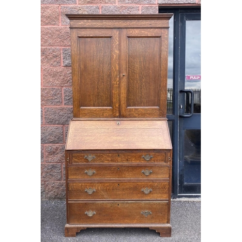 41 - A FINE GEORGIAN BUREAU BOOKCASE, with fluted cornice, two panelled doors above fold out desk with fi... 