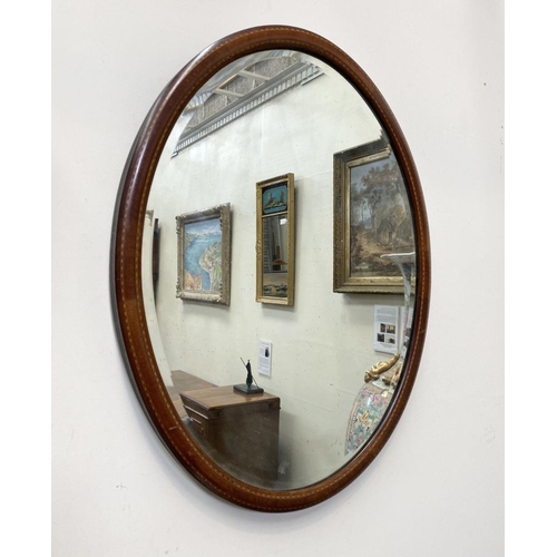 54 - A MAHOGANY INLAID OVAL WALL MIRROR, with bevelled glass, original glass plate, inlay details to fram... 