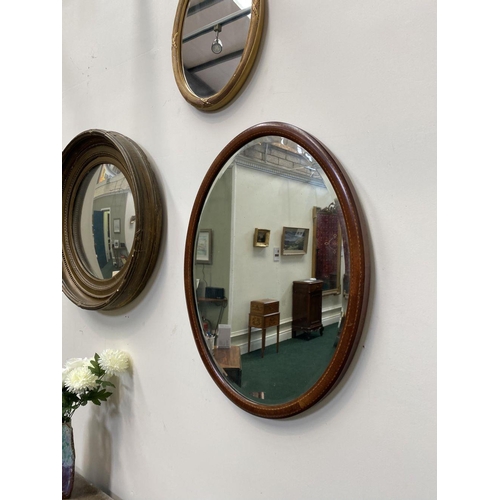 54 - A MAHOGANY INLAID OVAL WALL MIRROR, with bevelled glass, original glass plate, inlay details to fram... 