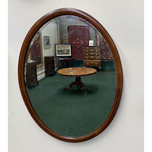 54 - A MAHOGANY INLAID OVAL WALL MIRROR, with bevelled glass, original glass plate, inlay details to fram... 