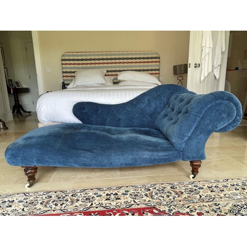 82 - A CHESTERFIELD STYLE BLUE VELVET CHAISE LOUNGE, with scroll armrest, button back detail, standing on... 