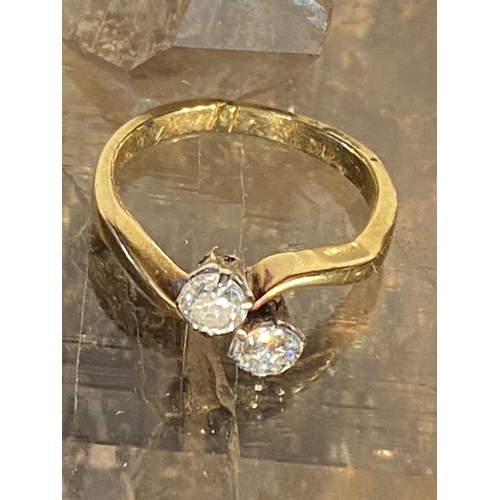 99 - A DISTINCTIVE 18CT YELLOW GOLD TWO STONE DIAMOND TWIST RING, the diamonds are claw set and weight .6... 