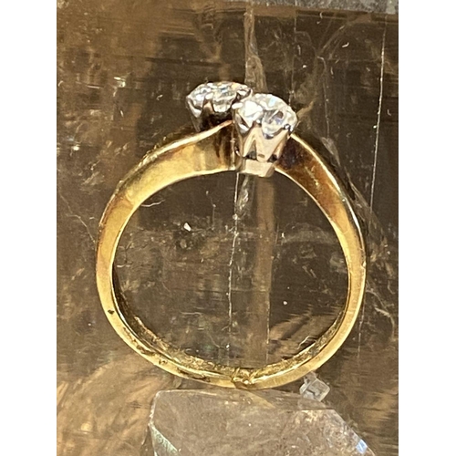 99 - A DISTINCTIVE 18CT YELLOW GOLD TWO STONE DIAMOND TWIST RING, the diamonds are claw set and weight .6... 