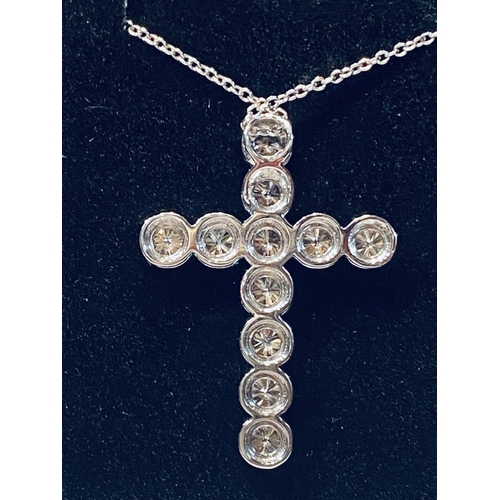 150 - A BRILLIANT CUT DIAMOND CROSS PENDANT, in a claw setting on an 18ct white gold chain. There are 11 G... 