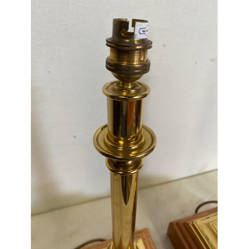 155 - A PAIR OF BRASS TABLE LAMPS IN THE STYLE OF CHANDLE STICKS, on a wooden base. 50cm tall. No shade.