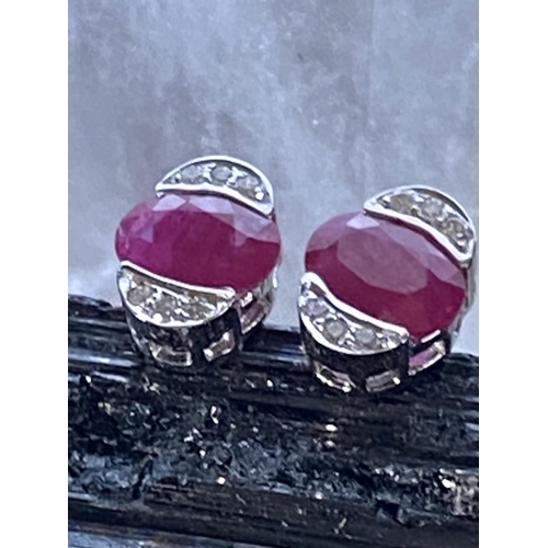 180 - A PAIR OF 18CT WHITE GOLD RUBY & DIAMOND STUD EARRINGS, oval in shape, with a centrally placed oval ... 