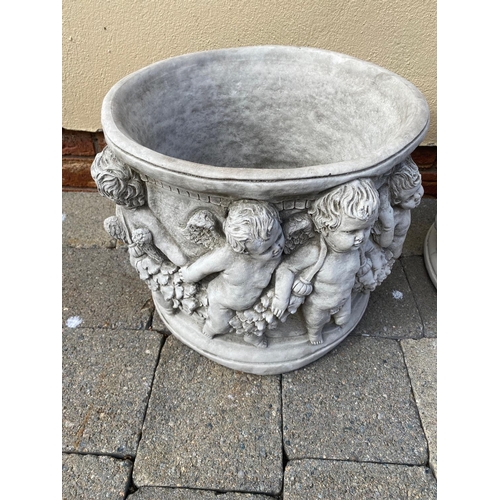 206 - A PAIR OF ROUND SHAPED STONE PLANTERS, decorated with a cherubs holding hands around the body of the... 