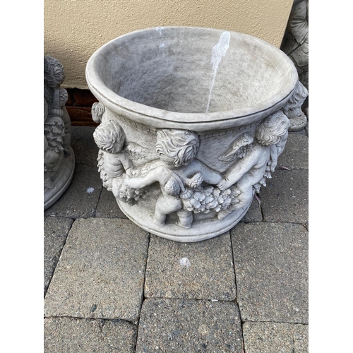 206 - A PAIR OF ROUND SHAPED STONE PLANTERS, decorated with a cherubs holding hands around the body of the... 