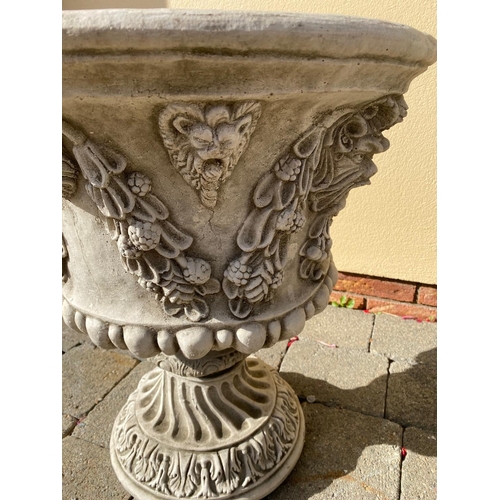 207 - A LARGE PAIR OF STONE GARDEN URNS, each with detailed decoration of fruit and foliage with green-man... 