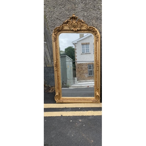 243 - A GILT OVER MANTLE / HALL MIRROR, with scrolling foliage design to the top and sides. Bevelled glass... 