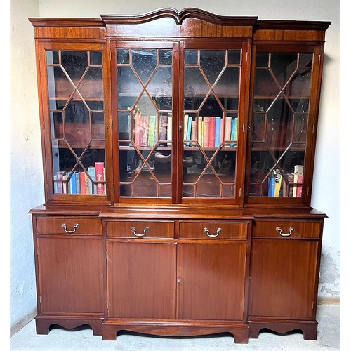 46 - A GOOD QUALITY IRISH MAHOGANY BREAK-FRONT LIBRARY BOOKCASE, the pediment with curved detail to the c... 