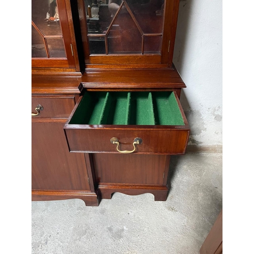 46 - A GOOD QUALITY IRISH MAHOGANY BREAK-FRONT LIBRARY BOOKCASE, the pediment with curved detail to the c... 