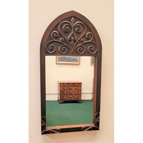 69 - A GOOD QUALITY EARLY 20TH CENTURY WALL MIRROR, Arts & Crafts style, with gothic shape and scrolling ... 