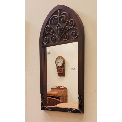 69 - A GOOD QUALITY EARLY 20TH CENTURY WALL MIRROR, Arts & Crafts style, with gothic shape and scrolling ... 