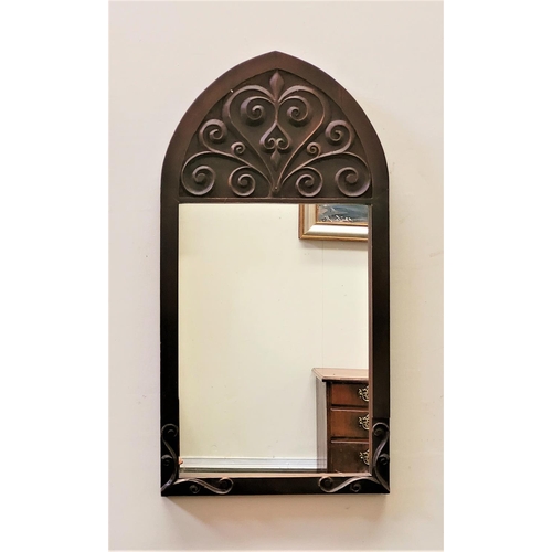 69 - A GOOD QUALITY EARLY 20TH CENTURY WALL MIRROR, Arts & Crafts style, with gothic shape and scrolling ... 