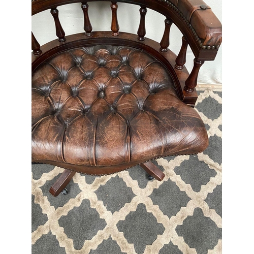 12 - A BROWN LEATHER DESK/CAPTAINS CHAIR, with button back, turned spindle supports to back, standing on ... 