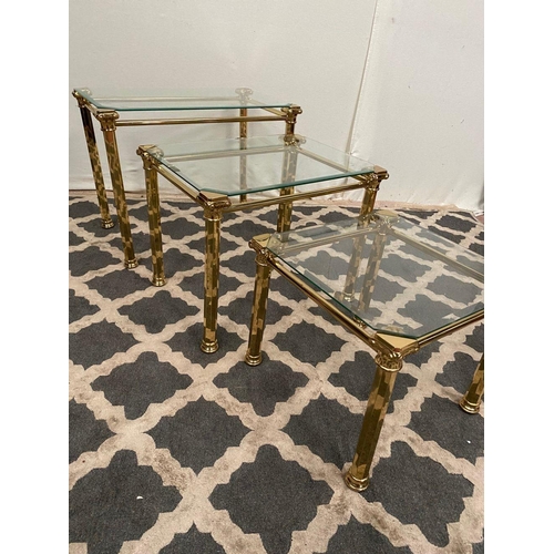 138 - A GOOD QUALITY NEST OF THREE BRASS TABLES, with bevelled glass tops on brass Corinthian column legs.... 