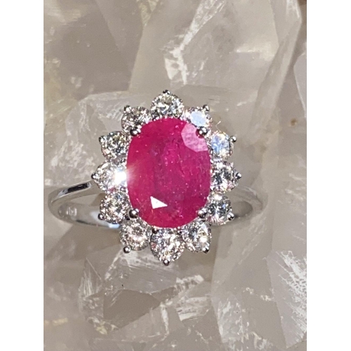 144 - A STRIKING 18CT WHITE GOLD BURMESE RUBY AND DIAMOND CLUSTER RING, the oval shaped Ruby weighs 2.70ct... 