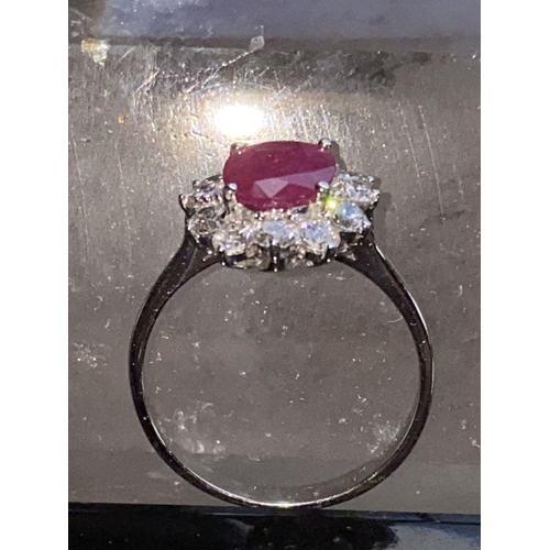 144 - A STRIKING 18CT WHITE GOLD BURMESE RUBY AND DIAMOND CLUSTER RING, the oval shaped Ruby weighs 2.70ct... 