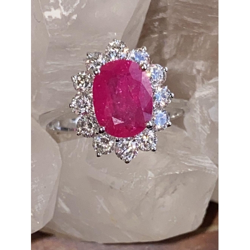 144 - A STRIKING 18CT WHITE GOLD BURMESE RUBY AND DIAMOND CLUSTER RING, the oval shaped Ruby weighs 2.70ct... 