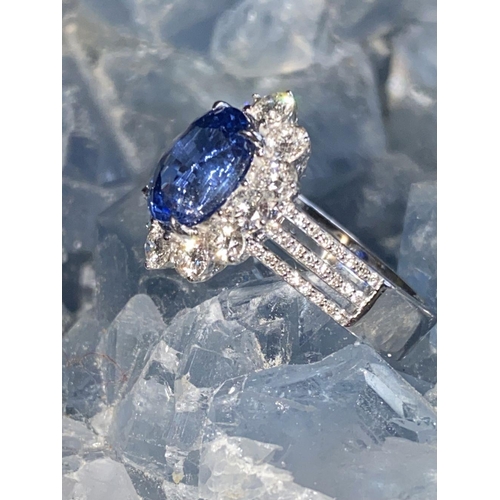 146 - A STATEMENT 18CT WHITE GOLD CEYLON SAPPHIRE AND DIAMOND CLUSTER RING, the natural oval shaped Ceylon... 