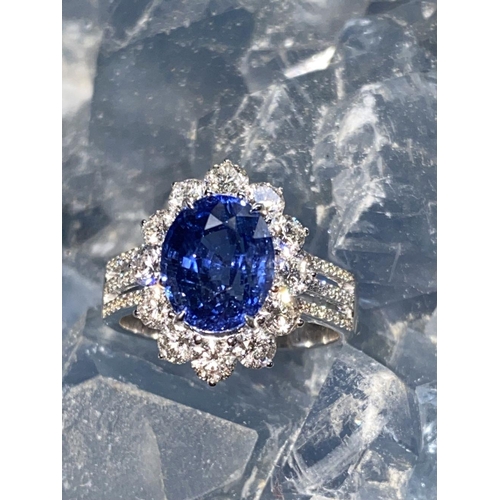 146 - A STATEMENT 18CT WHITE GOLD CEYLON SAPPHIRE AND DIAMOND CLUSTER RING, the natural oval shaped Ceylon... 