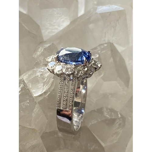 146 - A STATEMENT 18CT WHITE GOLD CEYLON SAPPHIRE AND DIAMOND CLUSTER RING, the natural oval shaped Ceylon... 