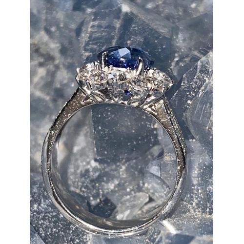 146 - A STATEMENT 18CT WHITE GOLD CEYLON SAPPHIRE AND DIAMOND CLUSTER RING, the natural oval shaped Ceylon... 