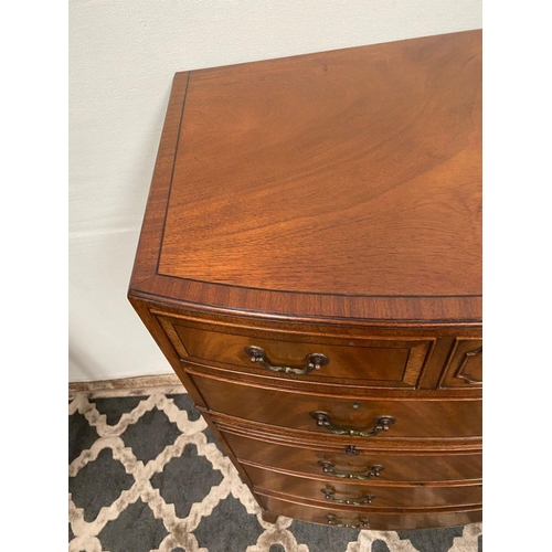 15 - A GOOD QUALITY BOW FRONTED CHEST OF DRAWERS, with brush slide in centre, five drawers with brass han... 