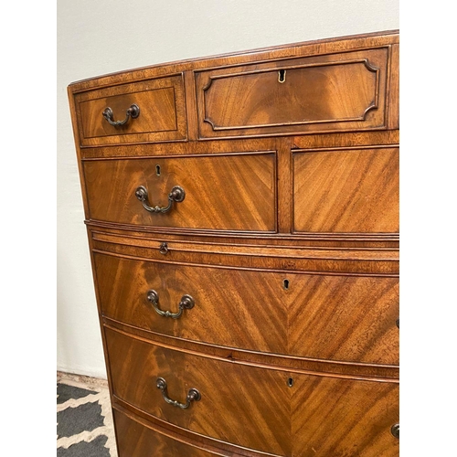 15 - A GOOD QUALITY BOW FRONTED CHEST OF DRAWERS, with brush slide in centre, five drawers with brass han... 