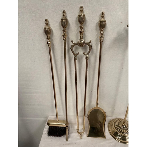 47 - AN EXCELLENT SET OF FOUR BRASS FIRE IRONS, all with finials to top, on circular platform stand. Dime... 