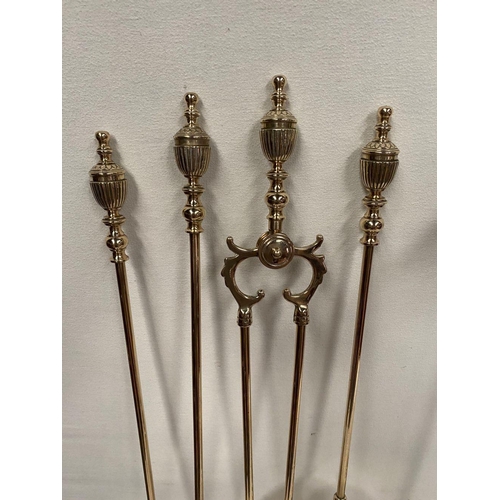 47 - AN EXCELLENT SET OF FOUR BRASS FIRE IRONS, all with finials to top, on circular platform stand. Dime... 