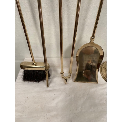 47 - AN EXCELLENT SET OF FOUR BRASS FIRE IRONS, all with finials to top, on circular platform stand. Dime... 