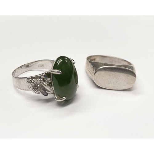 57 - A CONTINENTAL SILVER RING, with claw set jade/green cabochon coloured stone and decorative shoulders... 