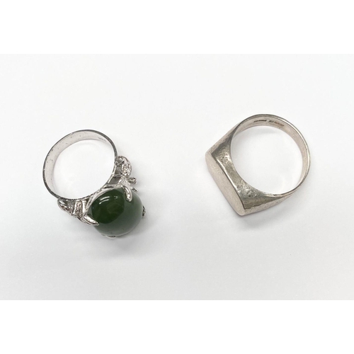 57 - A CONTINENTAL SILVER RING, with claw set jade/green cabochon coloured stone and decorative shoulders... 