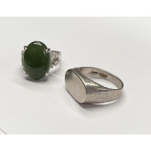 57 - A CONTINENTAL SILVER RING, with claw set jade/green cabochon coloured stone and decorative shoulders... 