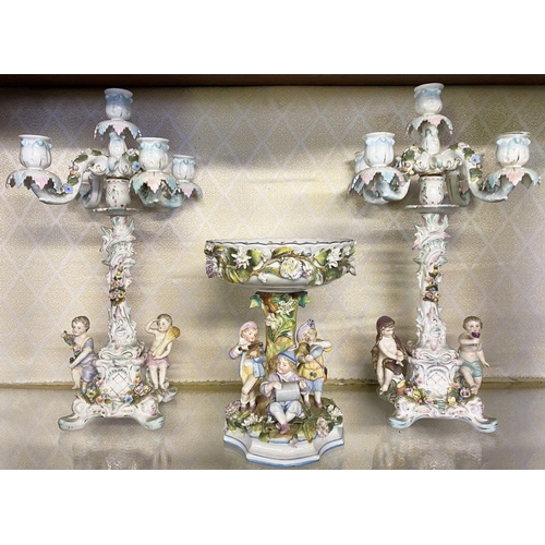 105 - AN ANTIQUE GERMAN SITZENDORF CENTREPIECE AND PAIR OF MEISSEN PORCELAIN CANDLEABRA, with five branche... 