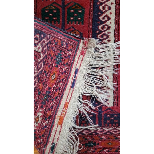 124 - A VERY GOOD QUALITY HAND KNOTTED BUKARA STYLE PRAYER RUG, with long fringe on each end. Condition; v... 