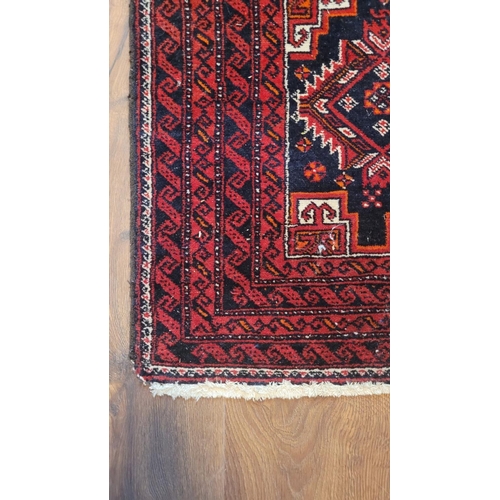 130 - A GOOD QUALITY VINTAGE BALUCH FLOOR RUG, main ground red, with central set of 8 medallions surrounde... 