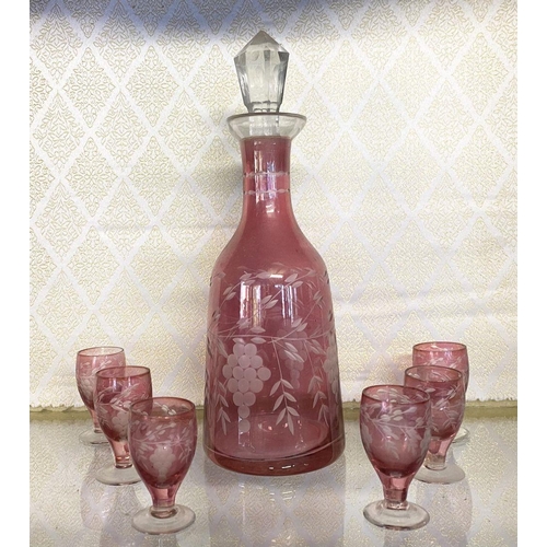 131 - A VINTAGE CRANBERRY ETCHED GLASS DECANTER ALONG WITH SIX CLEAR FOOTED GLASSES, grape floral design e... 