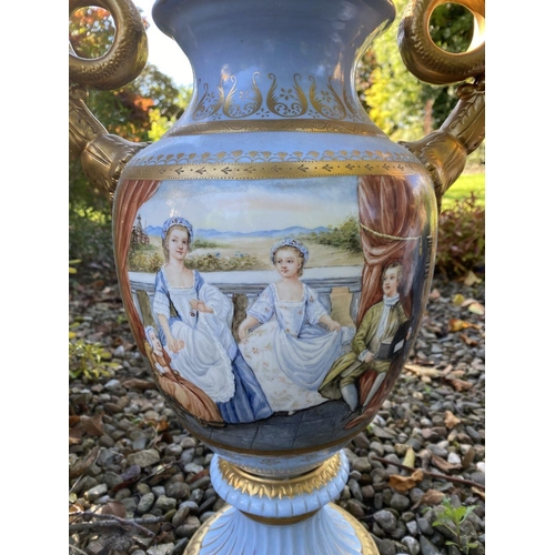 15 - A PAIR OF FRENCH STYLE SERVES PORCLEAIN TWO HANDLED URN VASES, with painted panels to front and reve... 