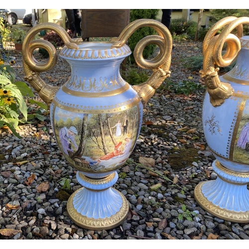 15 - A PAIR OF FRENCH STYLE SERVES PORCLEAIN TWO HANDLED URN VASES, with painted panels to front and reve... 