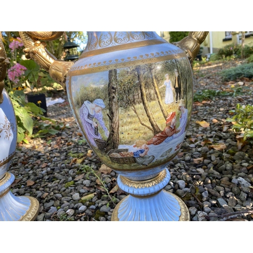 15 - A PAIR OF FRENCH STYLE SERVES PORCLEAIN TWO HANDLED URN VASES, with painted panels to front and reve... 