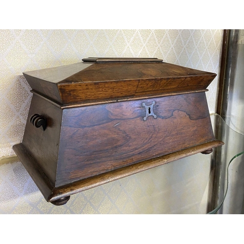 158 - AN ANTIQUE ROSEWOOD TEA CADDY, sarcophagus form, with scroll handles, standing on flattened bun feet... 