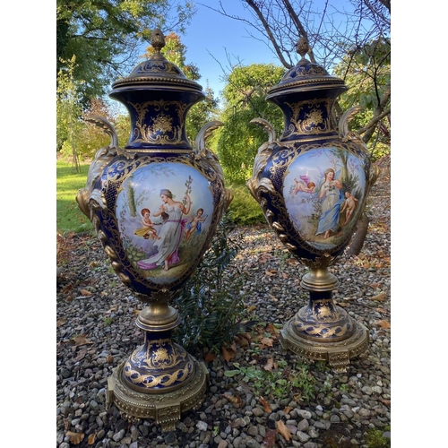 18 - A PAIR OF LARGE FRENCH SERVES PORCELAIN COVERED VASES, with ornate decoration including painted pane... 