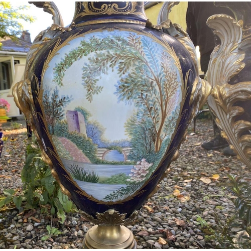 18 - A PAIR OF LARGE FRENCH SERVES PORCELAIN COVERED VASES, with ornate decoration including painted pane... 