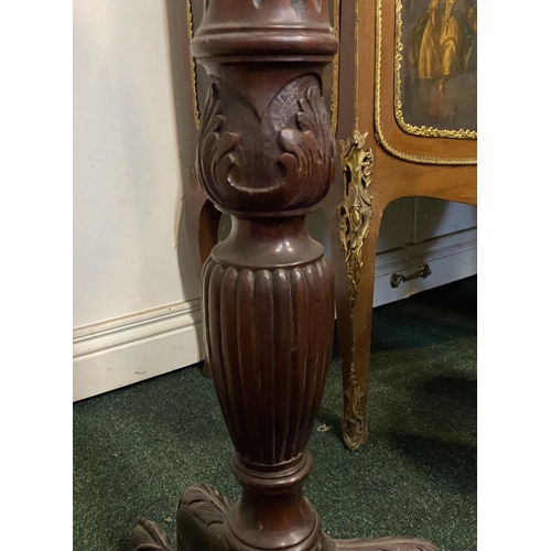 212 - A CARVED MAHOGANY PEDESTAL STAND, with circular top, turned and elaborately carved support atop trip... 