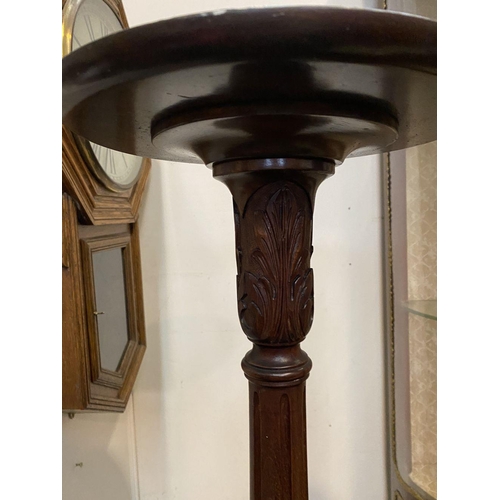 212 - A CARVED MAHOGANY PEDESTAL STAND, with circular top, turned and elaborately carved support atop trip... 