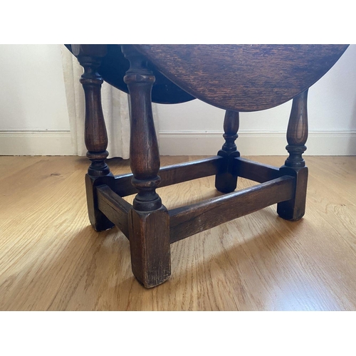 213 - AN ANTIQUE OAK DROP-LEAF SIDE TABLE, with turned gate legs, oval top when opened. Dimensions: 68cm x... 