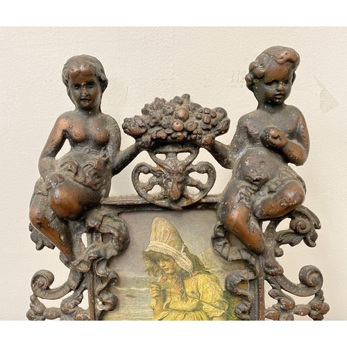 22 - A VICTORIAN CAST METAL PICTURE FRAME, featuring ornate design with two figures to top with floral cr... 